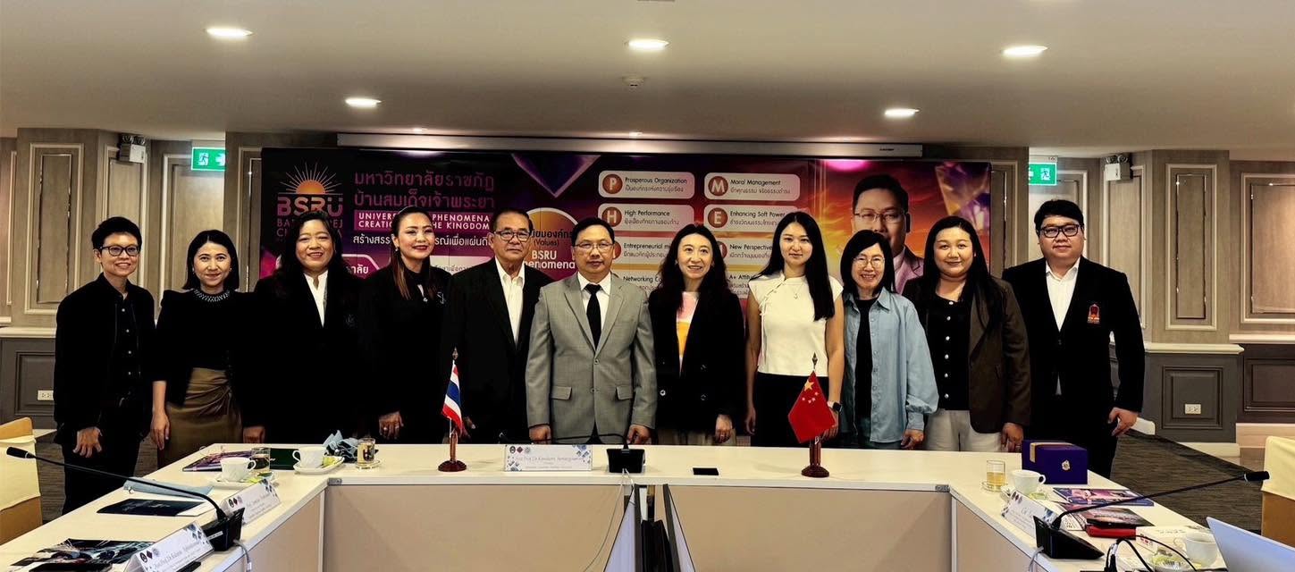 Thai and Chinese delegates posing behind a conference table with desk flags