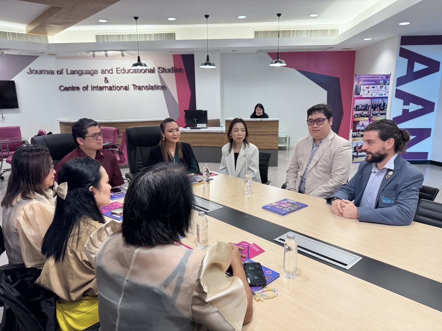 Eight delegates seated around a conference table in discussion